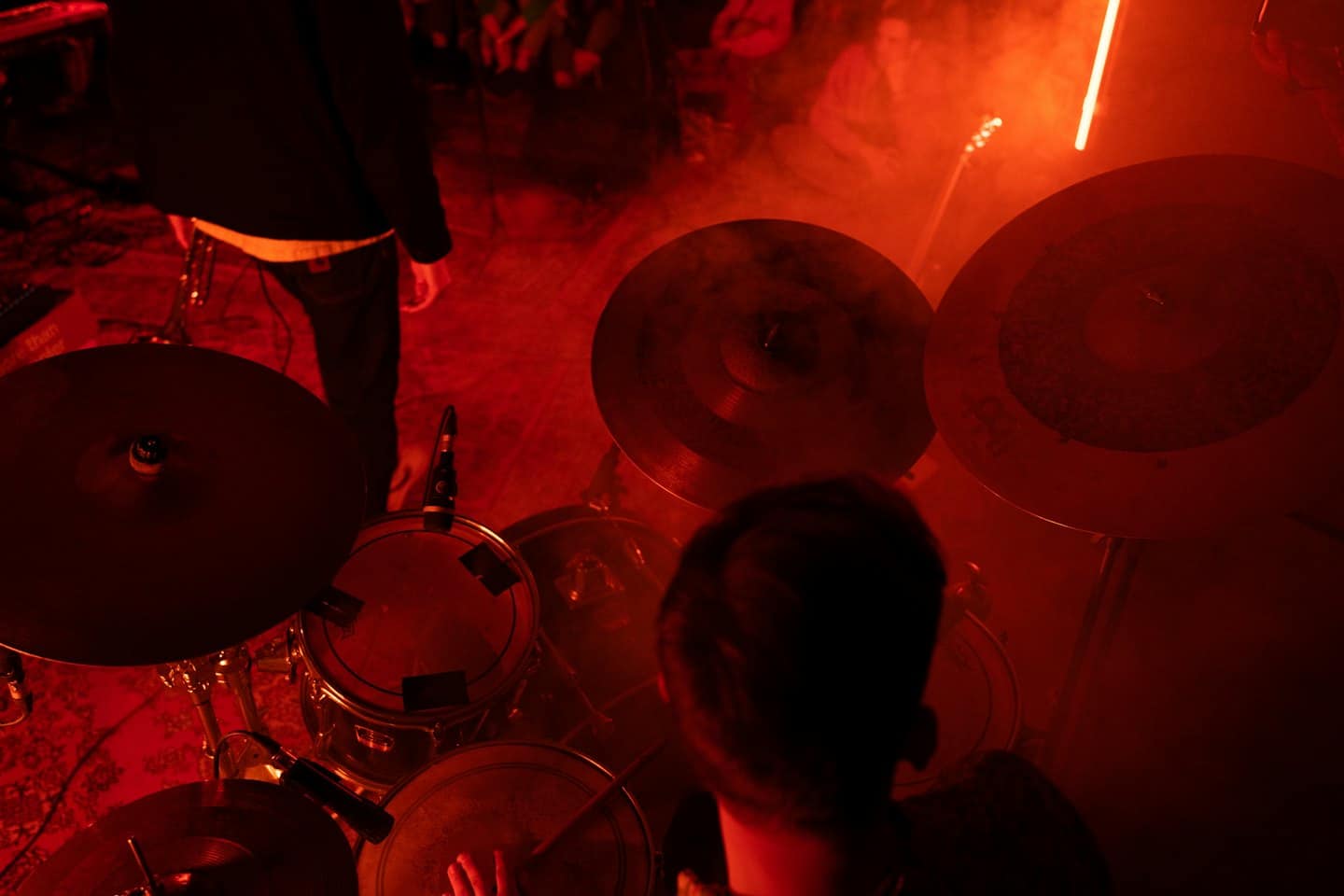 Un musicista suona la batteria su un palco durante uno spettacolo.