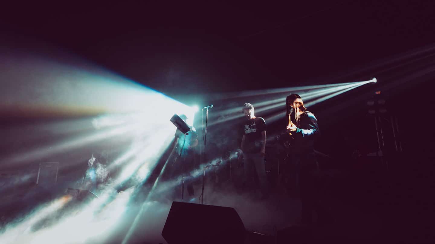 Musicisti si esibiscono su un palco poco illuminato.