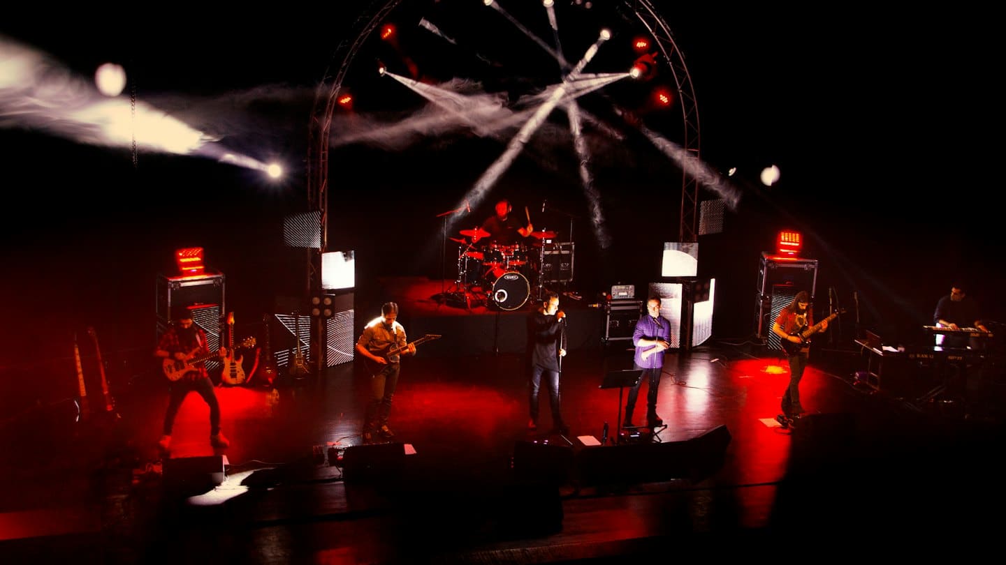 Sei musicisti si esibiscono insieme su un palco da concerto.